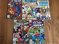 Top-down view of five Marvel comic books spread on floor showing front covers including Spider-Man #201, Hulk #205, Vision and Scarlet Witch #12, Amazing Spider-Man #35, and What If Hulk #21