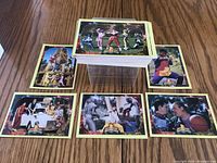 Stack of Power Rangers trading cards and six individual cards arranged around it, showing character images including the Red Ranger and others.