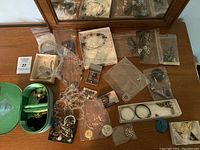Wide view of various necklaces, bracelets, rings, earrings and brooches laid out on tabletop