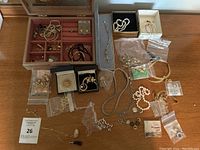 Overview of open jewelry box and loose jewelry spread on table