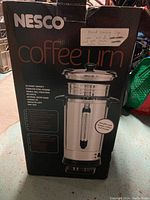Front view of the Nesco coffee urn box showing model name, capacity and features.