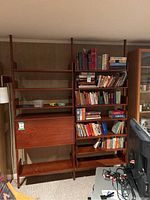 Front view of entire three-column mid-century modern floating shelf unit with book contents