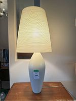 Front view of lamp lit, showing base and composite shade.