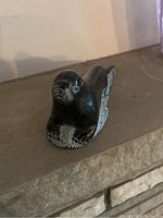 Close-up photo of soapstone bird sculpture showing detailed feather patterns and polished surface