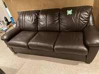 Front view of the brown three seat couch showing all cushions and armrests.