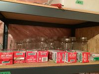 Shelf with clear glass jars in medium size and boxes of Bernardin snap lids