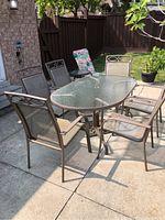 Full view of patio set showing table, chairs, and loungers in outdoor setting