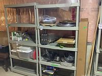 Front view of two beige plastic shelving units with multiple shelves, showing size and structure. Some items are on shelves but not included in sale.