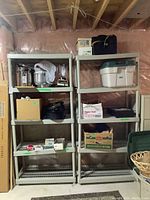 Two beige plastic shelving units side by side in basement with various items stored on shelves.