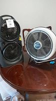 Photo of both fans together on a wooden table showing general size and shape.