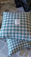 Two blue and white houndstooth pattern pillows stacked, showing pattern and condition
