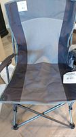 Front view of folding camping chair showing fabric seat and metal frame, with mesh center section for ventilation.