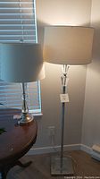 Photo showing both the floor lamp and table lamp side by side, highlighting their size difference and styles