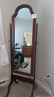 Front view of standing full-length mirror showing wooden frame and mirror surface.