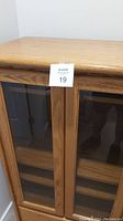 Close-up front view of wooden stereo cabinet glass doors and wooden frames