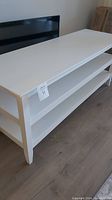 White wooden TV stand with three shelves, good quality and excellent condition
