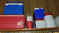 Shelf display of multiple coolers and thermoses of various sizes, showing overall lot contents