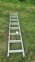 Extension ladder fully extended on grass, showing two sections with 16 rungs in total.