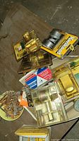 Photo of assorted brass and metal locks, some in original packaging, set on a table.