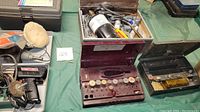 Wide view of open soldering station with multiple soldering tips and accessories inside and nearby tools