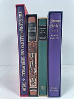 Spine view of four hardcover Folio Society books with decorative slipcases: The Pre-Raphaelites and Their World, The Lantern Bearers, Experience of an Irish R.M., and Thomas Becket.