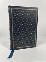 Front cover showing dark blue leather with gold embossed diamond pattern and floral motifs