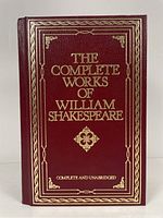 Front cover photo showing the red leather cover with gold embossed title and decorative border.