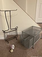 Photo showing a bronze metal toilet paper and magazine rack, metal under counter pull out shelf with two mesh wire drawers, and stained glass nightlight with decorative porcelain base.