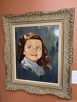 Front view of the child portrait oil painting with ornate carved frame.