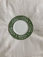 Single green and white plate laid flat on fabric background.
