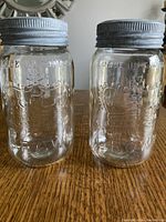 Two clear Crown glass sealer jars with metal lids showing embossed crown logos and 'Made in Canada' lettering.