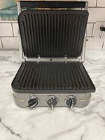 Front view of Cuisinart Griddler opened showing ribbed grill plates and control knobs