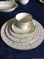 Stacked bone china plates and cup set showing floral pattern and platinum rim on ivory background