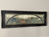 Full view of the rectangular framed pastoral artwork with distressed black frame depicting houses and rolling hills.