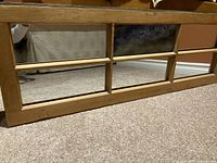 Close-up image of pine wooden frame mirror with multiple square mirror panels.