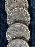 Close-up image showing three Dutch silver coins with profile of Queen Wilhelmina and inscriptions.