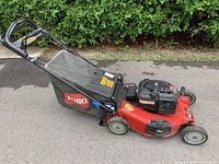 Side profile of mower showing red deck, engine and grass catcher