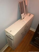 Broan 30-inch range hood in large white box with original packaging visible, along with a smaller package containing replacement filters on top.