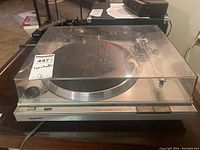 Full view of the Sony PS-T22 turntable showing dust cover and base unit on a dark surface.
