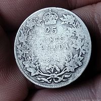 Reverse side of the 1911 Canada 25 cent silver coin showing denomination, country, date and maple leaf wreath design.