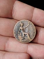 Reverse side of the 1916 UK Half Penny coin showing Britannia seated with trident and shield.