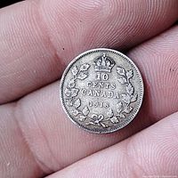 Reverse side of the 1918 Canadian 10 cent coin featuring the denomination, year, crown, and maple leaves wreath.