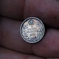 Obverse side of the 1919 Canadian 5 cents coin with denomination and maple leaves under a crown.