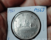 Obverse side of the 1951 Canadian silver dollar showing two men paddling a canoe and markings 'CANADA', '1951', and 'DOLLAR'.