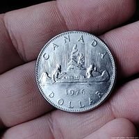 Reverse side showing the canoe with two paddlers and a voyageur, dated 1976 with Canada label.