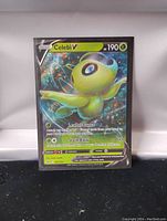 Photo of a full art foil Pokemon card featuring Celebi V with 190 HP and moves Leaflet Dance and Slash Back.