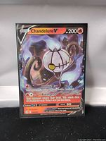 Clear photo of Chandelure V Full Art Pokemon card in protective sleeve showing front art and details.