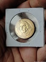 Obverse side of the coin showing George Washington's profile and inscriptions, held in a protective holder.