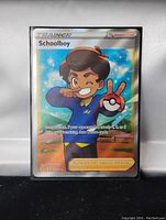 Front view of a Pokemon Trainer card labeled Schoolboy featuring full art holo foil of a boy character with a Pokeball.