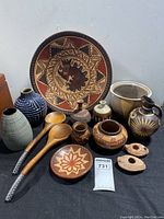Photo showing the entire lot with pottery and wooden spoons on black background